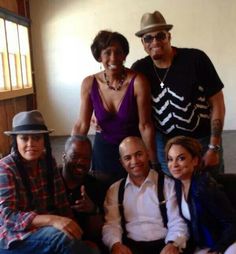 a group of people that are sitting on a couch together and posing for the camera