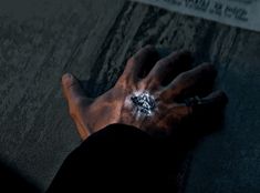 a person's hand on the ground with white powder sprinkled on it