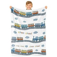 a young boy holding up a blanket with trains on it and the words cho cho