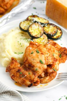 a white plate topped with chicken and mashed potatoes