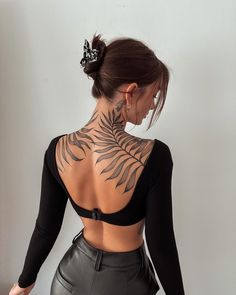 the back of a woman's body with tattoos on her upper and lower back