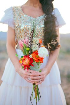 a woman holding a bouquet of flowers in her hands