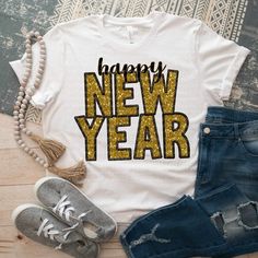 a t - shirt with the words happy new year written on it next to ripped jeans