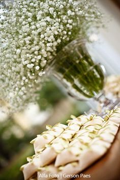 flowers are in a vase and some food is sitting on a table next to each other