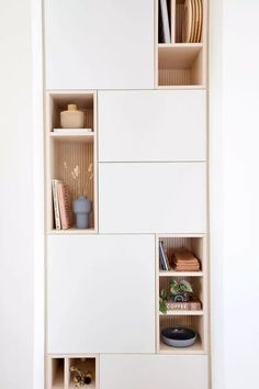 an open shelf with several different items on it in a room that has white walls and flooring