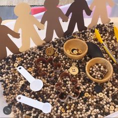 a bowl filled with buttons and paper cutouts on top of a pile of gravel