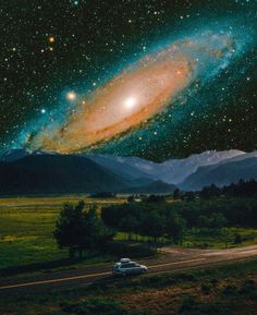 a car driving down a road with mountains in the background and a large star filled sky