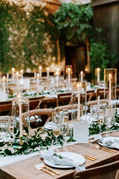 the table is set with candles, plates and napkins for dinner guests to enjoy