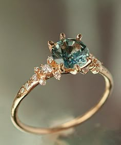 a gold ring with an aqua and white diamond