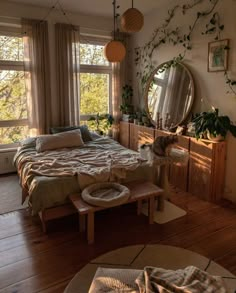 a bed room with a neatly made bed next to two windows and a cat laying on the floor