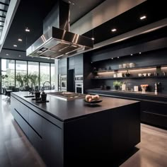 a large kitchen with black cabinets and counter tops, along with an island in the middle