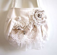 a white purse with lace and flowers on it