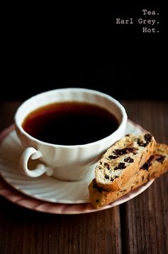 a cup of tea and some cookies on a plate with the words'tea, barley, hot '