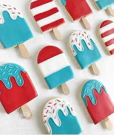 decorated ice cream popsicles are arranged on a white surface with red, white and blue icing