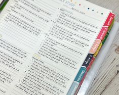 a close up of an open book on a table with writing utensils next to it