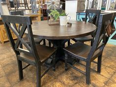 a wooden table with chairs around it in a room filled with other furniture and decor