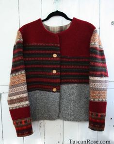 a red and grey sweater hanging on a white wall