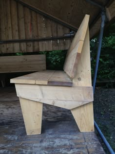 a bench made out of wood sitting under a roof