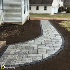 a brick walkway in front of a white house