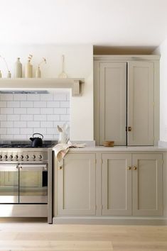 a kitchen with an oven, stove and cupboards in the middle of the room