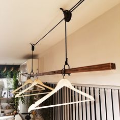 three wooden hangers with clothes hanging from them