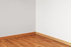 an empty room with hard wood floors and white walls