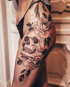 a woman's thigh with a skull and flowers on it