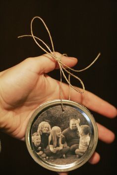 a hand holding an ornament with some small children on it's side