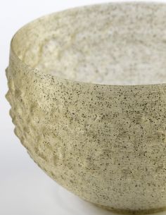 a close up of a stone bowl on a white surface with black speckles