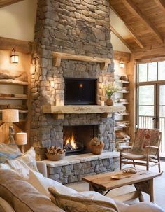 a living room with a stone fireplace and couches in front of the fire place