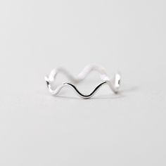 This dainty silver wiggle ring is a fun ring to add to your daily lineup. This ring can be worn on it's own, or combined with our other rings to create a stacked look. Made from .925 sterling silver, it is sure to be a piece that lasts. Each piece is custom-made for you, so please allow 1-5 days for the jewelry to ship. - .925 Sterling Silver - 1.1mm band - Handmade to order - Comes neatly packaged in a kraft jewelry box ready for gifting Trendy Adjustable Sterling Silver Rings, Adjustable White Gold Midi Rings With Simple Design, Adjustable Silver Midi Rings For Everyday Wear, Trendy Sterling Silver Stackable Rings, Trendy Nickel-free Sterling Silver Rings, Trendy Sterling Silver Stackable Rings For Everyday, Minimalist Silver Toe Rings As Gift, Trendy Sterling Silver Midi Rings For Everyday, Minimalist Silver Toe Rings For Gift