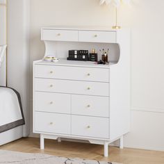 a white dresser sitting next to a bed in a room with a rug on the floor