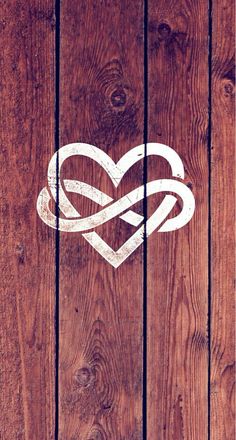 a heart with two intertwined hearts painted on it's wood paneled wall