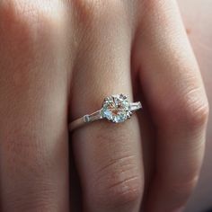 a woman's hand with a diamond ring on top of her finger and an engagement band