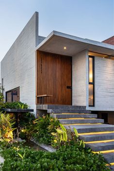 a modern house with stairs leading up to the front door