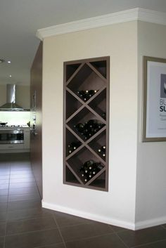 a wine rack in the corner of a room with tile flooring and white walls