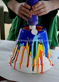 a person is decorating a cake with colorful icing on the top and bottom