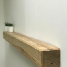 a wooden shelf with two small plants on it