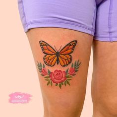 a woman's thigh with a butterfly and rose tattoo on it, next to her leg