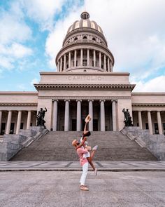 two people doing acrobatic tricks in front of the state capitol building