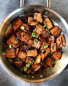 a pan filled with meat and vegetables on top of a table