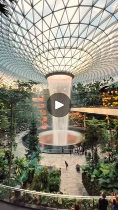 the inside of a building with people walking around and looking up at it's ceiling