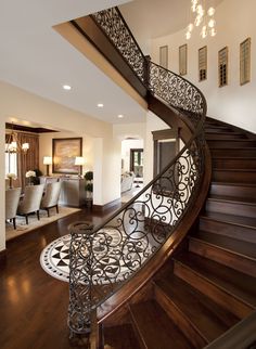 a spiral staircase in a home with wood floors and chandelier hanging from the ceiling