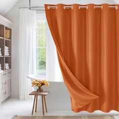 an orange shower curtain in a bathroom next to a white bathtub and window with open curtains