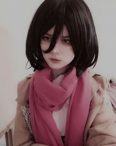 a woman with black hair wearing a pink scarf