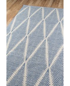 a blue and white area rug on the floor with wood floors in the background,