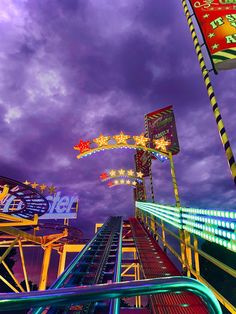 an amusement park ride at night with colorful lights on it's sides and the sky in the background