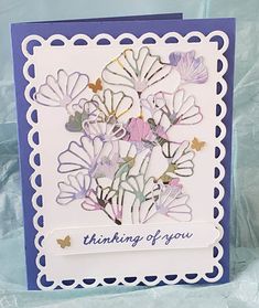 a handmade card with flowers on it and the words thinking of you written in blue