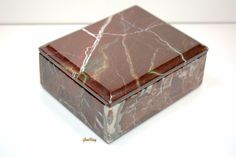 a red marble box sitting on top of a white table