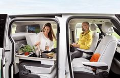 a man and woman sitting in the back of a white van with their trays full of food